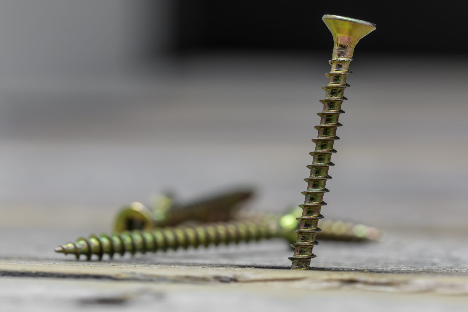 many of the screws looks beautiful on wooden background, closeup